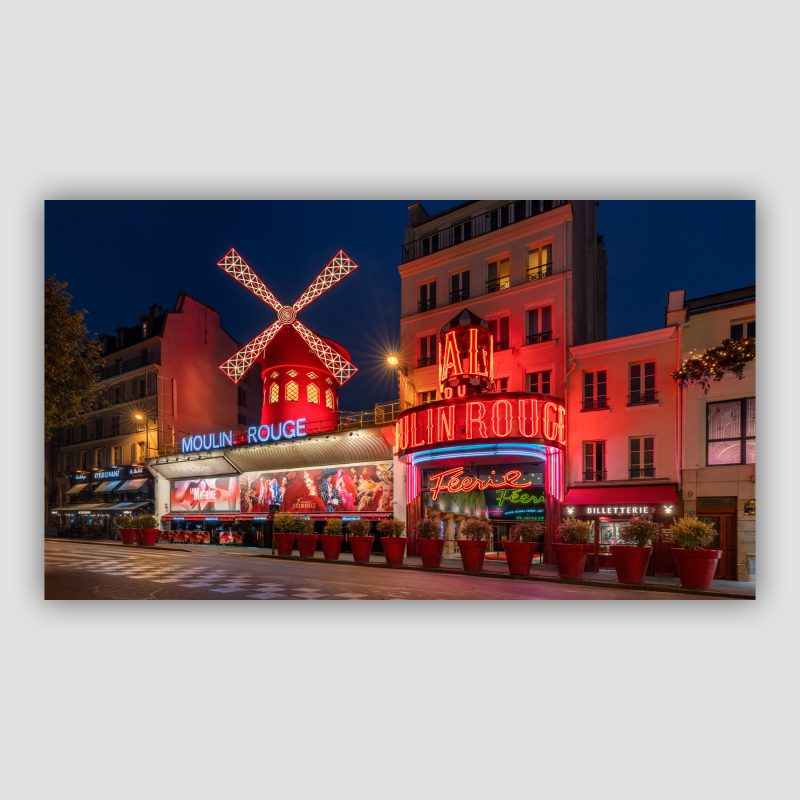 “The Naughty Mill” er original fotokunst, der leveres signeret og nummereret i Limited Edition. Velkommen til en verden af fjer, glitter og dans! Moulin Rouge på  Boulevard de Clichy på Montmartre i Paris er en indbegrebet af cabaret – og det er legendarisk sted med sine neonskilte og den flotte røde mølle.