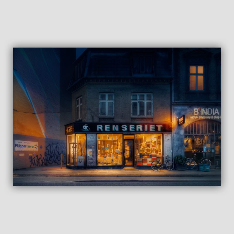 Kunstværket “Past and Present” er original fotokunst, der leveres signeret og nummereret i Limited Edition. Renseriet på Gl Kongevej er ikke længere et renseri, men derimod en interessant lille brugskunstbutik. Og så er den nabo til vores eget lille galleri, så vi får kigget meget på den. Vi kan dog huske det fra dengang, at det var et renseri. Skiltet er i dag gået i stykker, så der kun er halvdelen af bogstaverne tilbage, men oser jo af fordums tiders flotte butiksfacader. Vi har været tilbage i gamle historiske fotografier, for at finde ud af hvad der EGENTLIG stod på skiltet for at være i stand til at rekonstruere skiltet. Der stod "MS Renseriet" og så med en lille tegning af et skib. De manglende bogstaver har vi været i stand til at genskabe, ved omhyggelig klippen og klistren fra de overlevende bogstaver, og MS Skibet har vi måttet tegne selv. Det fjerner billedet fra bunken med dokumentariske billeder, og flytter det over i bunken med "billeder som har benyttet sig af kunstnerisk frihed". Noget som gør sig gældende for alle vores billeder. De er IKKE dokumentariske - men de er dog troværdige mod de steder vi fotograferer.