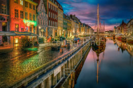 One of the major sites in Copenhagen lies in the heart of Copenhagen. It's called Nyhavn, and it means New Harbor. Here you find old houses and boats, and on a summer's day you can have a cold beer. I shot this photo just before sunrise and before the neon lights are turned off. Photo by: Jacob Surland, www.caughtinpixels.com
