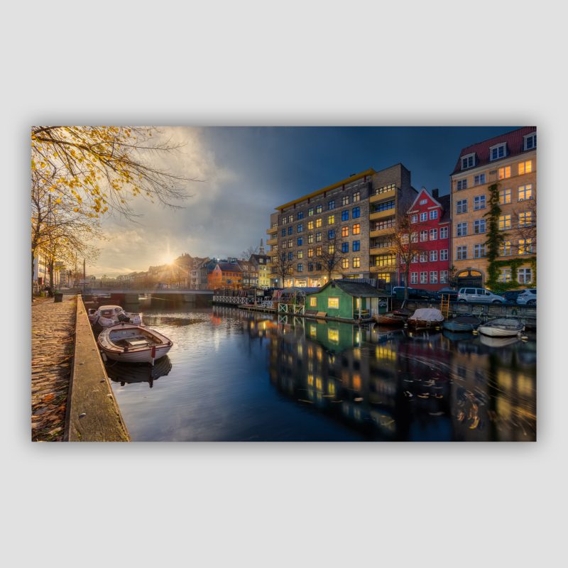“Haven” er fotokunst fra København, der leveres signeret og nummereret i Limited Edition. Den lille bådudlejning og Cafe i Christianshavns kanal på en fin efterårsaften. Her sammensat af billeder fra en hel aften, således at der både er solnedgang og sen aften i samme billede.