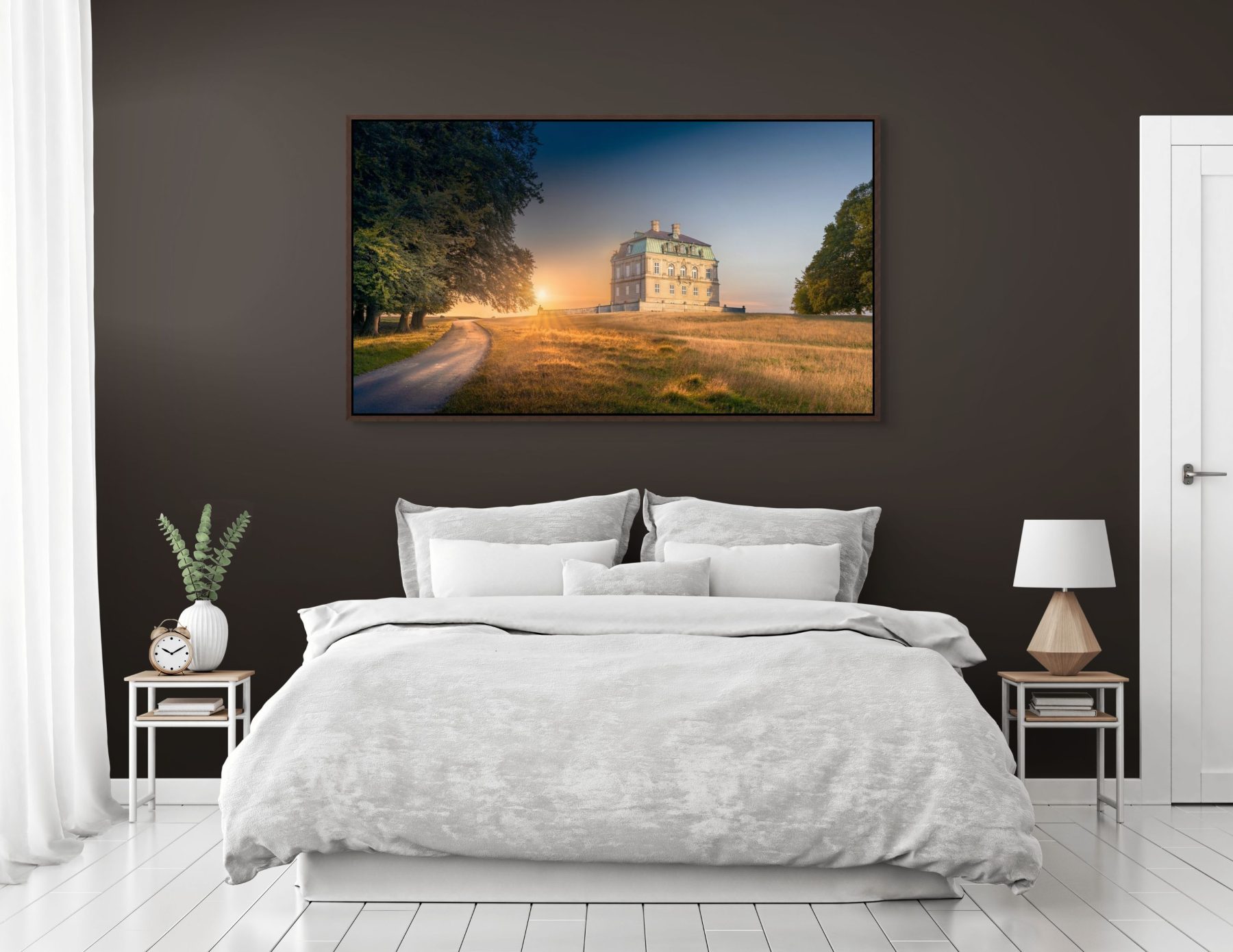Mockup af kunstværket "Et døgn ved Eremitageslottet" af Surland & Vesterager. Billedet hænger i et soveværelse eller et hotelværelse på en grå væg