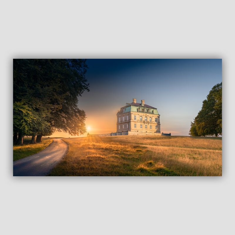 “Et døgn ved Eremitageslottet” er moderne dansk fotokunst, der leveres signeret og nummereret i Limited Edition. Eremitageslottet har været på vores todo-liste meget længe og vi har haft så mange fotografiske idéer med det. Vi endte med, at beslutte os for at lave tidssammensatte billeder hen over et døgn. Vi havde gang i fem kameraer samtidigt. Tre på denne her side og to på den anden side (så der kommer også et kunstværk fra den anden side på et tidspunkt). Vi stod på hver vores side og fotograferede, hvilket vagte stor nysgerrighed til folk som gik tur og kom forbi os begge to - to fotografer, som står med mere end et kamera og fotograferer slottet; gad vide hvad der foregår? Det er altid hyggeligt, når folk får et behov for, at få stillet deres nysgerrighed og kommer hen og spørger om hvad vi fotograferer.