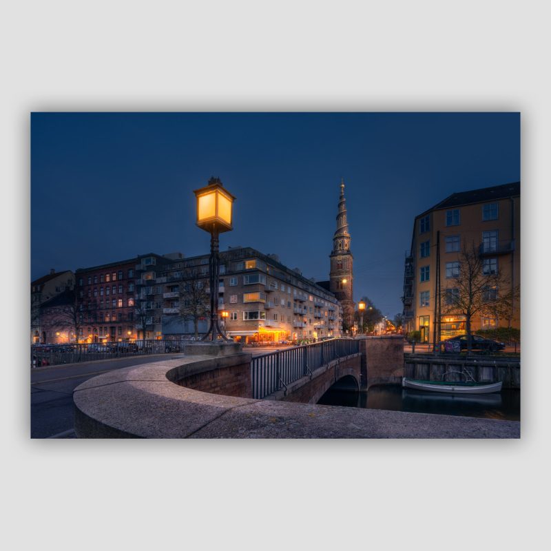 "Grace of Enlightment" er original dansk fotokunst af kunstnerparret Surland & Vesterager, der leveres signeret og nummereret i Limited Edition. Billedet viser Snorrebro med Vor Frelser Kirke i baggrunden.