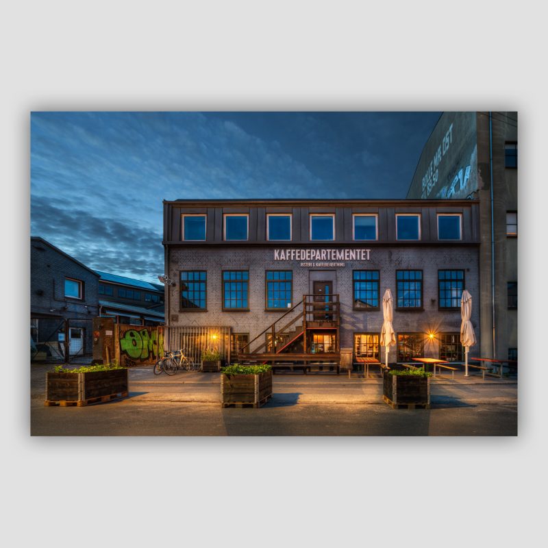 Kunstværket “Kaffedepartementet” er original fotokunst fra København, der leveres signeret og nummereret i Limited Edition. Ingen af os har for alvor haft vores gang i Nordvest på noget tidspunkt i vores liv. Derfor måtte vi også lavet noget research før vi drog derud for at fotografere og besluttede bl.a. at kigge forbi Rentemestervej. Vi valgte en af de lyse nætter, fordi så også havde vi mere tid til at gå på opdagelse, mens vi var derude. Kaffedepartementet, er foruden det kodylt fede navn også en mega fed bygning.