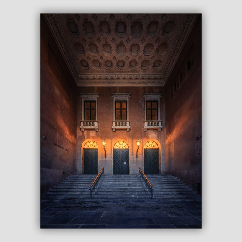 "Københavns Byret" er original fotokunst af Surland & Vesterager. Københavns Byret afgør hver dag skæbner, store som små. Her, ved hovedindgangen, mødes en flot arkitektur med skæbnerne, og giver stedet en næsten højtidelig atmosfære. Indenfor håndteres retfærdigheden af dommere og advokater.