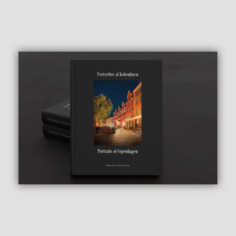 Portrætter af København er en ekstraordinær Coffee Table Book og et helt kunstværk i sig selv. Bogen samler en række af vores portrætter af Københavns bygninger og byrum og har desuden et tekstafsnit med noget af vores tankegods. Vi har brugt 3–4 år på at skabe den, fordi vi gerne vil vise et udvalg af vores fotokunst i et lækkert og anderledes format. En eksklusiv kunstbog i stort format. Portrætter af København rummer mere end 500 sider og er opbygget med skiftende papirtyper, fold-ud-opslag og lakerede sider, der fremhæver udvalgte billeder. Variationerne i materialer og tryk er nøje valgt, for at skabe en særlig visuel og taktil oplevelse. Det store format giver dig mulighed for virkelig at gå på opdagelse i detaljerne i vores billeder. Bogen er indbundet i sort recycled læder og leveres i en elegant kassette. Og så er den naturligvis produceret i Danmark.